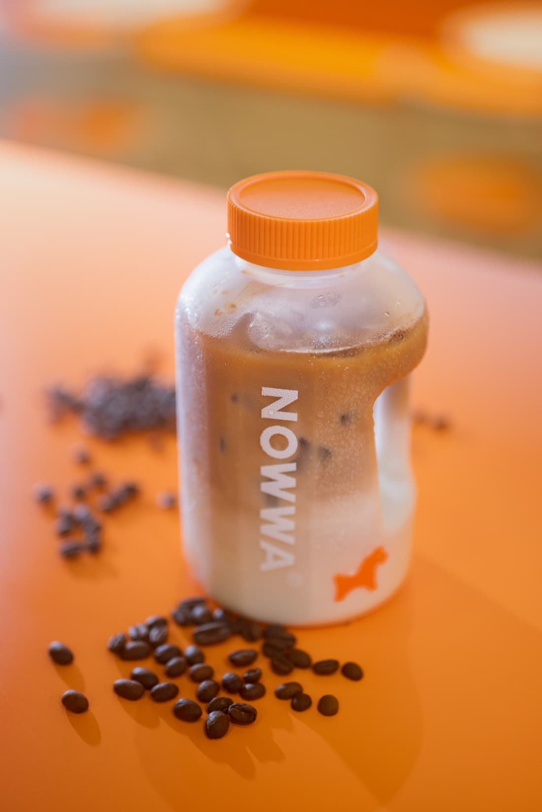 A chilled NOWWA iced coffee with coffee beans