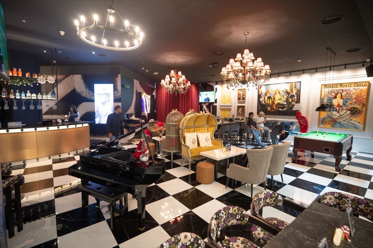 The X Society lounge — grand piano, pool table and chandeliers